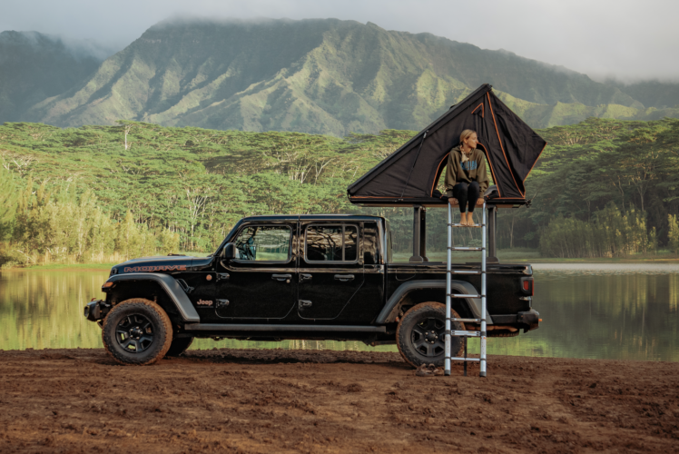 A woman sitting in Jeep Gladiator with camper